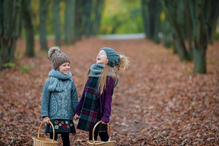 Two adorable girls in forest at warm sunny autumn dayの写真素材
