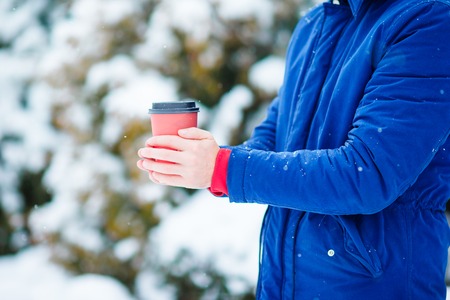 Happy man drinking coffee outdoors in winter timeの写真素材