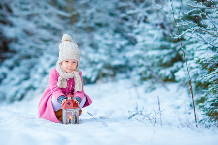 Cute little girl with christmas box gift in winter dayの写真素材