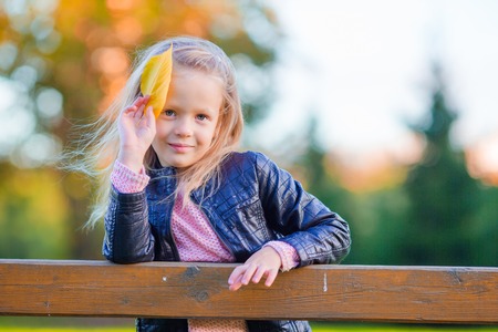 Adorable little girl at beautiful autumn day outdoorsの写真素材
