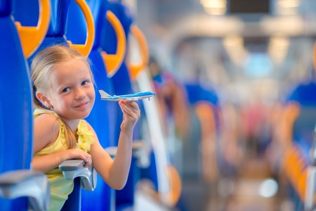 Happy little girl traveling by train and smilingの写真素材