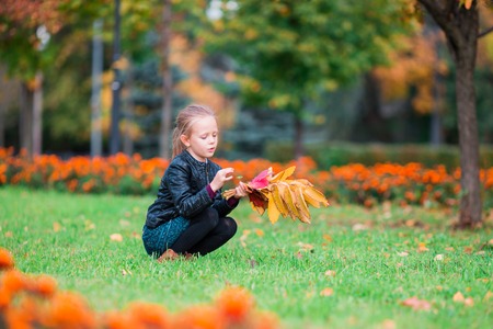 Adorable little girl at beautiful autumn day outdoorsの写真素材