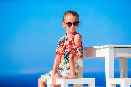 Adorable little girl having breakfast at restaurantの写真素材