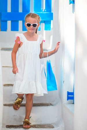 Girl in blue dresses having fun outdoors on Mykonos streetsの写真素材