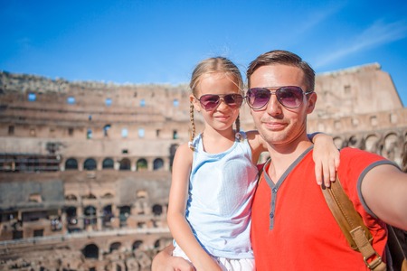 Young father and little girl taking selfie in Coliseum. Family portrait at famous places in Europe.の写真素材