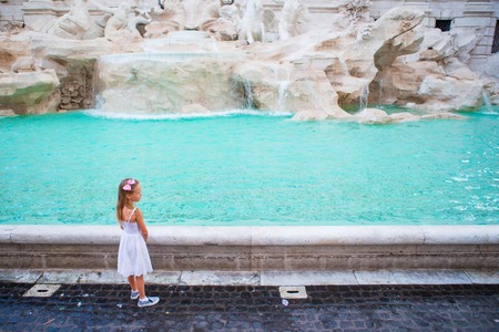 Adorable little girl near the Fountain of Trevi in Rome. Happy kid enjoy their european vacation in Italyの写真素材