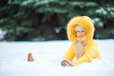 Little happy adorable girl in snow sunny winter dayの写真素材