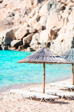 Beach wooden chairs and umbrellas for vacations on beach in Greeceの写真素材