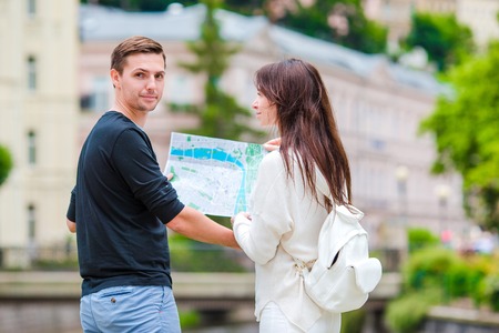 Young tourist couple traveling on holidays in Europe. Caucasian family with city map in search of attractionsの写真素材