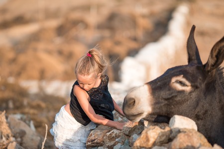 Little girl with donkey on the island of Mykonos