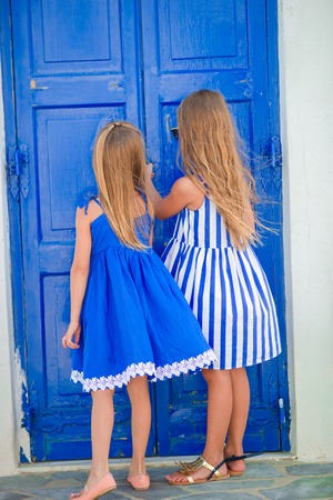 Cute little girls at street of typical greek traditional village in Greeceの写真素材