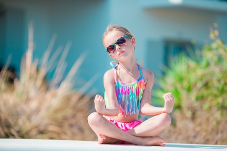 Portrait of adorable little girl in yoga outdoor on vacationの写真素材