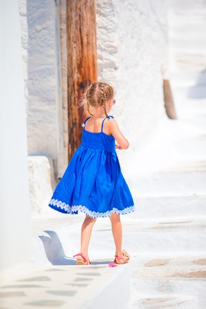 Adorable little girl at street of typical greek traditional village on Mykonos Island, in Greeceの写真素材