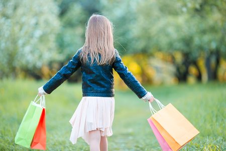 Adorable little girl with shopping bags outdoorsの写真素材