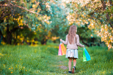 Adorable little girl with shopping bags outdoorsの写真素材