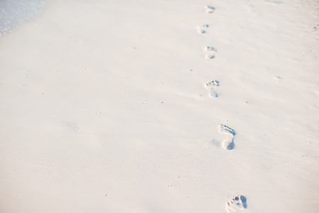 Footprints in the sand at sunset. Footsteps on the shore.の写真素材