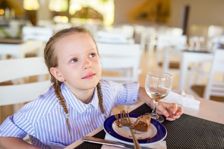 Adorable little girl having breakfast at resort restaurantの写真素材