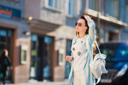 Happy young girl tourist in european city. Caucasian woman walking along the old streets of Europeの写真素材