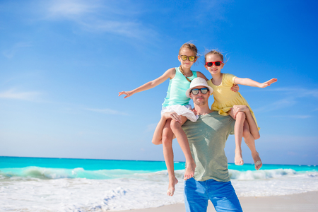 Family of dad and kids walking on white tropical beach on caribbean island have a lot of funの写真素材