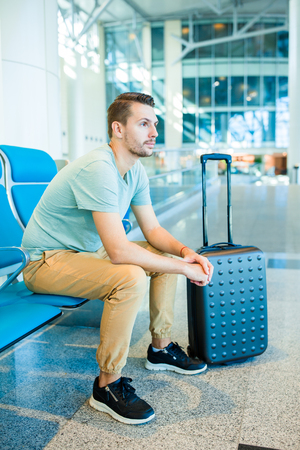 Young man in an airport lounge waiting for flight aircraft.の写真素材