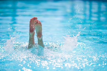 Happy little girl having fun in outdoor swimming pool