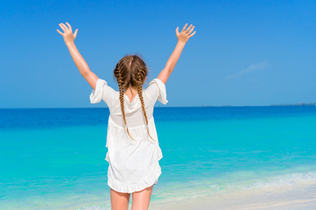 Amazing little girl at beach having a lot of fun on summer vacation. Adorable kid jumping on the seashoreの写真素材