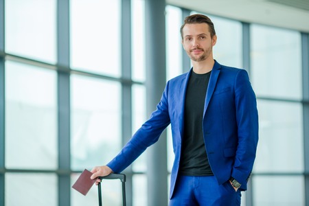 Young tourist man with passport and boarding pass at airport ready for travelingの写真素材