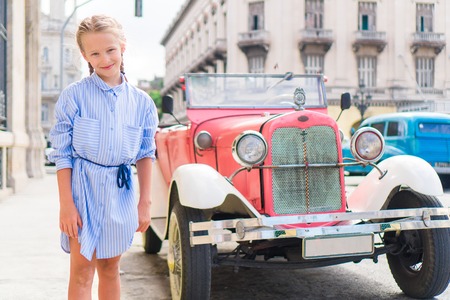 Adorable little girl in popular area in Old Havana, Cuba. Portrait of kid background vintage classic...