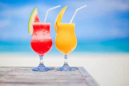 Two cocktails of watermelon and mango on background of stunning turquoise seaの写真素材