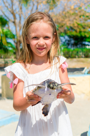 Adorable little girl with a small turtle in her hands in the natural reserveの写真素材