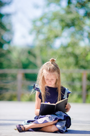 Adorable little school girl with notes and pencils outdoor. Back to school.の写真素材
