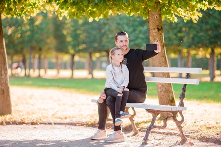 Happy family in fall. Father and little kid have fun taking selfie on beautiful autumn dayの写真素材