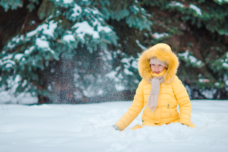 Happy little adorable girl in snow outdoorsの写真素材