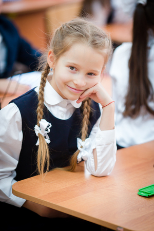 Portrait of adorable little school girl in classroomの写真素材