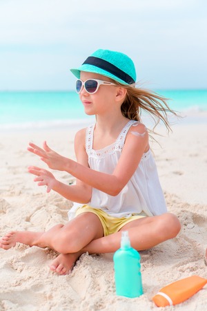 Little girl with bottle of sun creamの写真素材