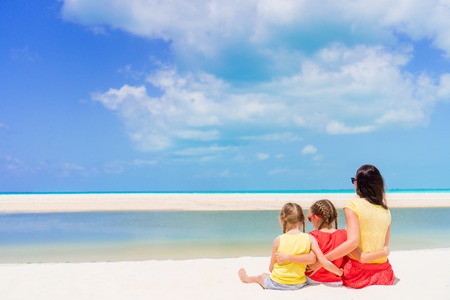 Adorable little girls and young mother on white beachの写真素材