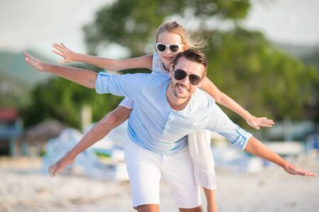 Little girl and happy dad having fun during beach vacationの写真素材