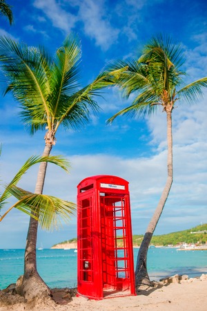 Red phone booth in Dickensons bay Antigua. Beautiful landscape with a classic phone booth on the white sandy beach in Antiguaの写真素材