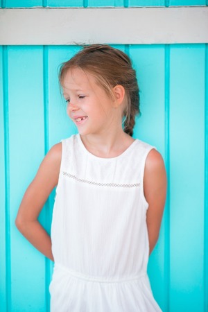 Adorable little girl outdoors against colorful house in Caribbean. Traditional caribbean colorful...