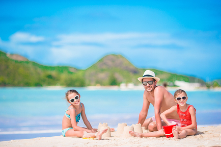 Family making sand castle at tropical white beach.の写真素材