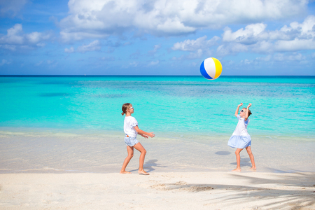 Little adorable girls playing with ball on the beachの写真素材