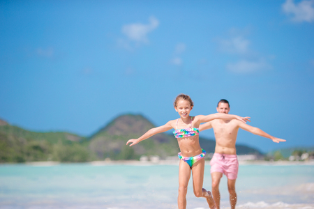 Happy father and his adorable little daughter at tropical beach walking togetherの写真素材