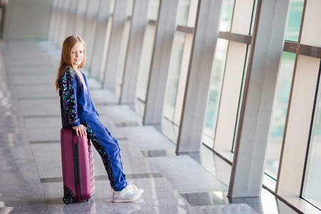 Adorable little girl in airport near big windowの写真素材