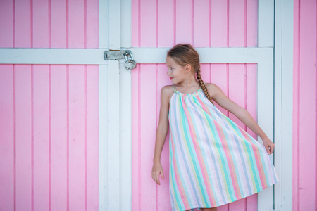 Little cute girl standing near bright colored wallの写真素材