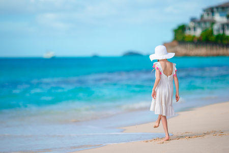 Beautiful little girl in dress at beach having fun.の写真素材