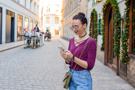 Woman talk by her smartphone in city. Young attractive tourist outdoors in italian cityの写真素材
