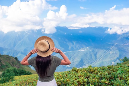 Beautiful happy young woman in mountains in the background of fogの写真素材