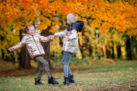 Little adorable girls at warm sunny autumn day outdoorsの写真素材