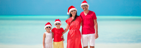 Happy family with two kids in Santa Hat on summer vacationの写真素材