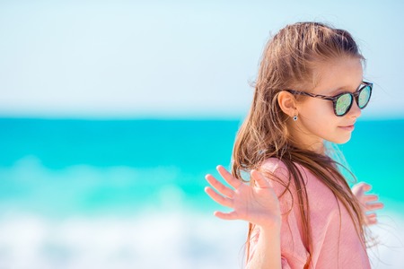 Beautiful little girl at beach having fun. Funny girl enjoy summer vacation.の写真素材